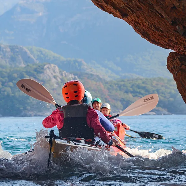 Kayaker paddling across calm turquoise water